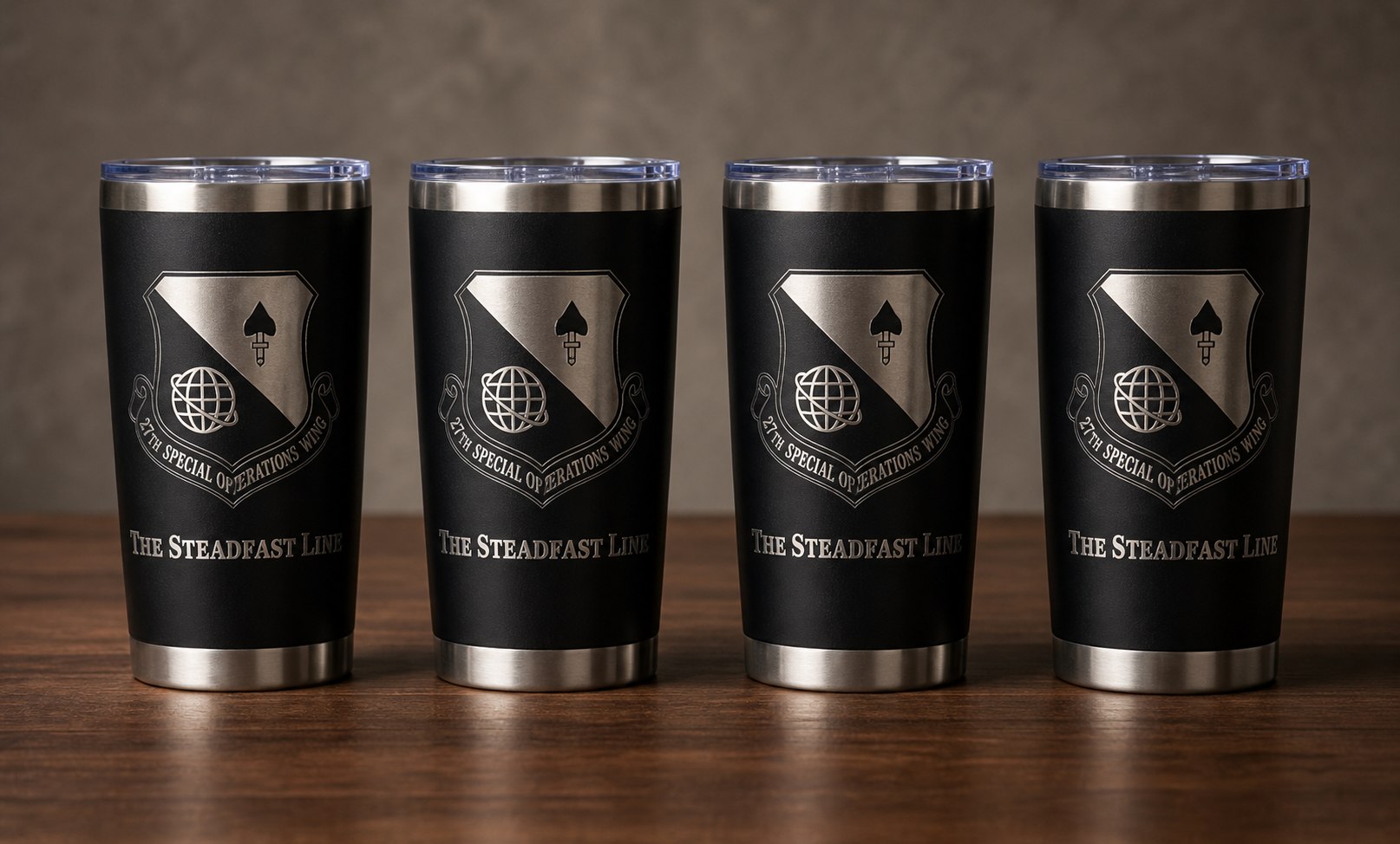 Four black tumblers with matching engraved team emblems.